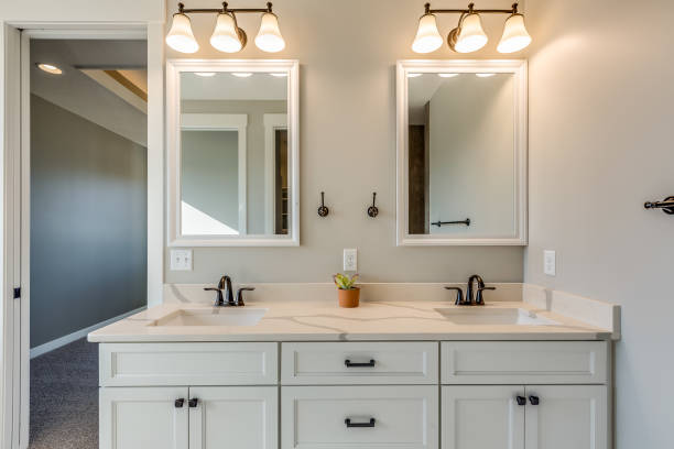 2 mirrors with vanity mirrors, white walled bathroom with white cabinet -vanity mirrors